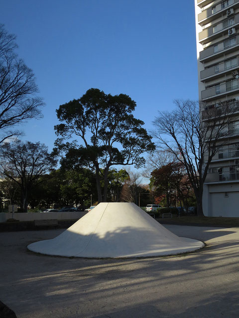 多摩市のURの団地内の公園には不思議なモニュメントが点在する。あえて言うならば京都・銀閣寺の向月台。何の為に作られたのか。子ども達が上り下りするには傾斜が急過ぎる。そのモニュメントに秋の陽が光と影を作っていた。なんだか雪をかぶった富士山に見えてきた。目的はこれ？まさかな・・・。2023.11.29　【多摩市豊ヶ丘2-2】