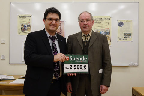 Mitglied des Stiftungsrates, Bruno Gärtner (r.), hat anlässlich der Vorstellung des Buches „Gartenkunst und Rosenduft – Die Leidenschaften des Friedrich Ries aus Eichtersheim“ 2.500,- Euro an Bürgermeister Frank Werner (l.) übergeben
