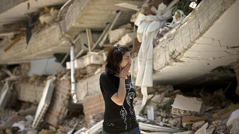 Mujer aterrorizada ante la destrucción a causa de un terrremoto