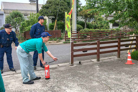 消防士さんの指導で水消火器で放水の訓練。