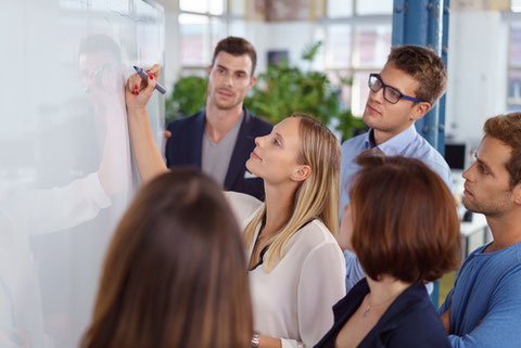 des participants a un atelier qui travaillent au tableau