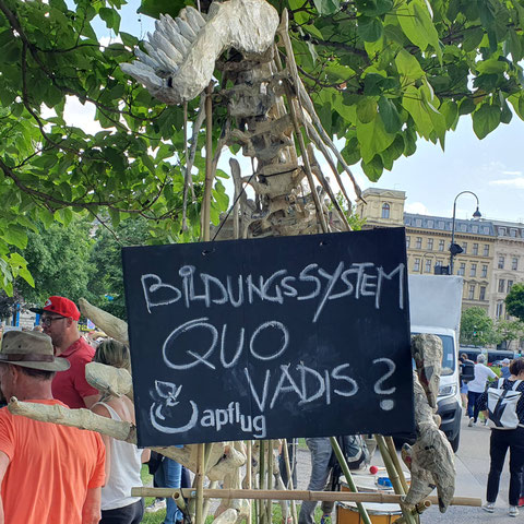 Ein Dinosaurierskelett mit Schild: Bildungssystem Quo Vadis?