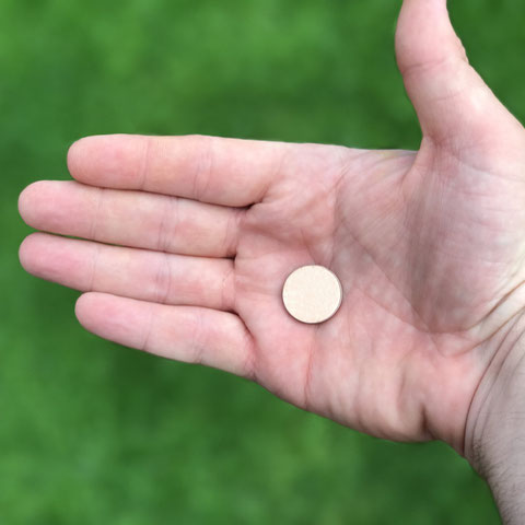 Eine winzige Münze liegt auf einer geöffneten Handfläche
