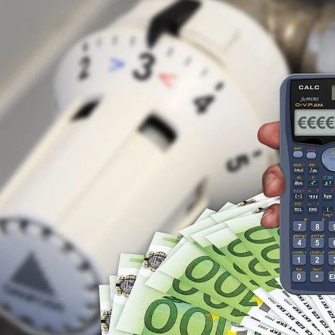 Bildmontage: Ein Heizthermosthat, ein Bündel Geldscheine und ein Taschenrechner