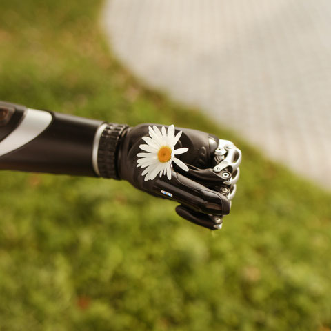 Eine Armprothese hält eine Blume