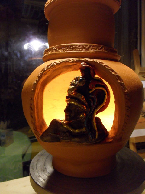 Vaso in pirofila rossa decorato con smalti e lustri tra i quali oro zecchino. Può diventare una lampada o un brucia essenze.