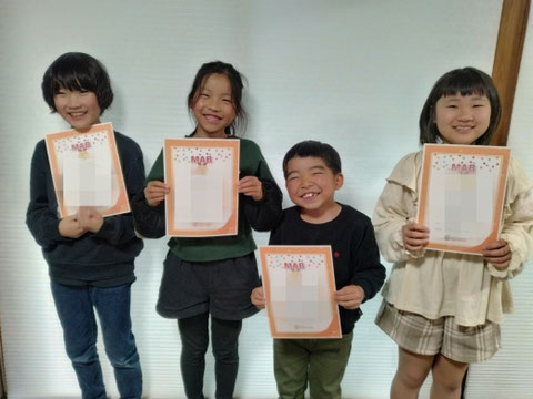📸 修了証を手に笑顔の子どもたち。 年度末に各レベルを修了すると達成の証として「修了証」が授与されます。頑張った1年の成果を誇らしげに手にする瞬間です！