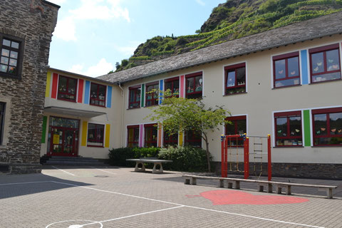 Schulhof mit Spielgeräten und Seiteneingang
