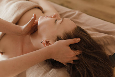 Femme en train de se faire masser le crâne et se relaxe en institut de beauté