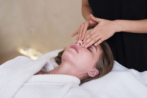 Femme train de se faire masser le visage