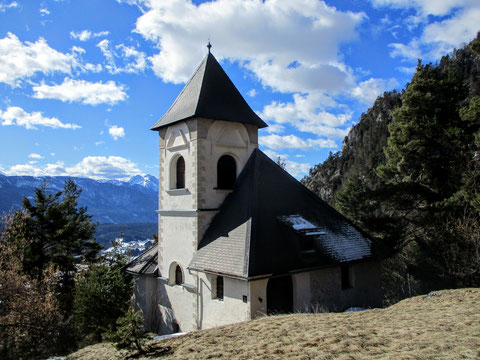 Kleine weiße Bergkirche mit schönem Ausblick und blauem Himmel, Berge im Hintergrund