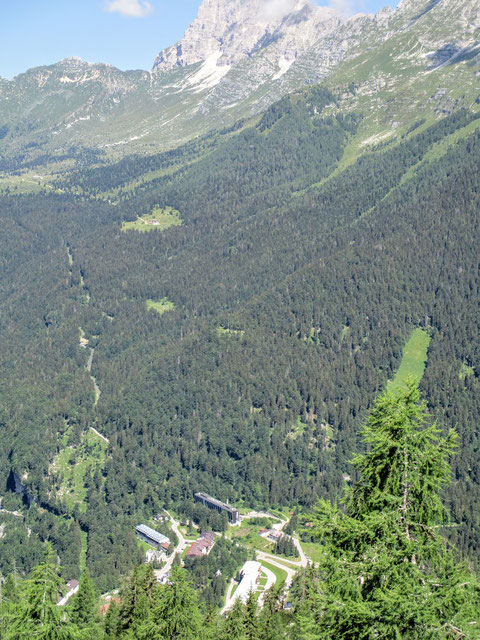 Tiefblick hinunter nach Selle Nevea, schön zu sehen die Straße hinauf zur Pecol-Alm und darüber der mächtige Gipfelaufbau des Montasch (2.754 m)
