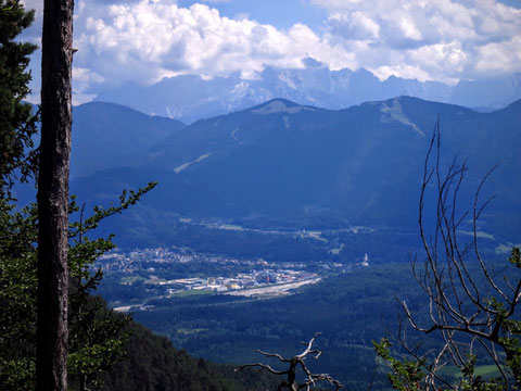 Blick über Arnoldstein mit dem Dreiländereck und den wolkenverhangenen Giganten der Julischen Alpen im Hintergrund