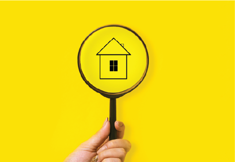 A magnifying glass centred over line art of a house