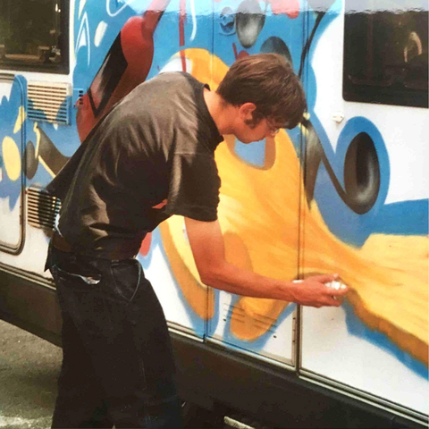 Ein Graffiti Sprayer der ein Wohnmobil besprüht