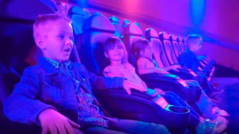 Kinder im Kino auf erhöhten Kindersitzkissen