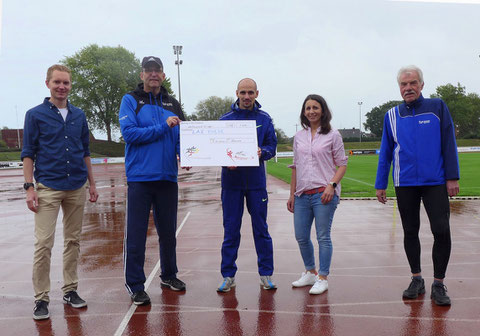 Andreas Beulertz (links) und Laura Lienhart vom Orga-Team Silvesterlauf begleiten die Scheckübergabe von Marathonläufer Hendrik Pfeiffer (Mitte) an Jürgen Palm (2. v. l.). Rechts: LAZ-Vorsitzender Andreas Böing.