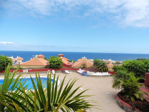 Blick aus der Ferienwohnung über den runden Pool bis zum blauen Atlantik vor Teneriffa.