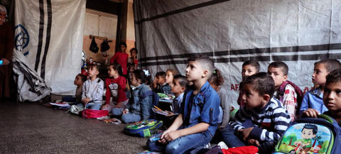 Niños sentados en el suelo reciben clase en una escuela improvisada en Deir al Balah, en el centro de Gaza. Unicef ha lanzado una campaña de "vuelta al colegio". Foto: ONU