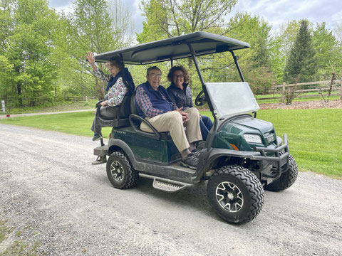 The ClubCar 'Onward' cart being used to transport older visitors with mobility limitations around Distant Hill in 2024.