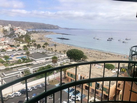 Weitblick vom Balkon auf den Strand und bis zum Horizont über das Meer.
