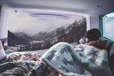 Frau beim Wintercamping im Wohnmobil mit Ausblick auf Winterlandschaft 2026