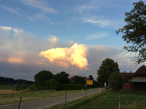Ortseingang Brachfeld, am Abendhimmel sieht man eine gelblich/golden leuchtende "Gewitterwolke"