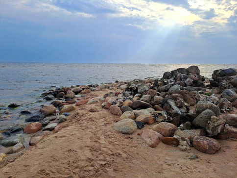 Rocky tip of Cape Kolka in Latvia with a ray of light breaking through the clouds