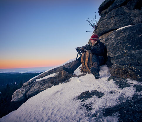 Der Fotograf Christopher Rau in Aktion: hier beim fotografieren eines Sonnenaufganges auf verschneiten Felsen im winterlichen Fichtelgebirge
