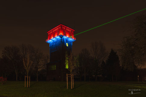 Hammerkopf-Förderturm der Zeche Erin Schacht 3 in Castrop-Rauxel im Ruhrgebiet bei Nacht mit Laser Strahl