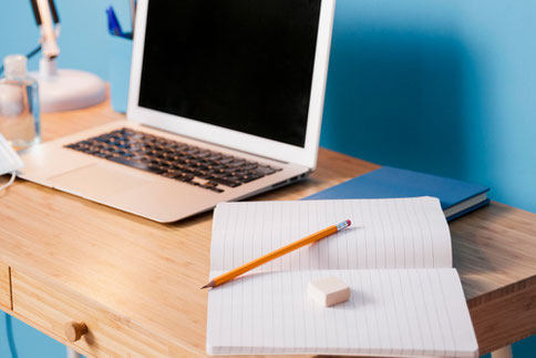 Un escritorio con una computadora portátil y un cuaderno, simbolizando el aprendizaje personalizado del español con tecnología.