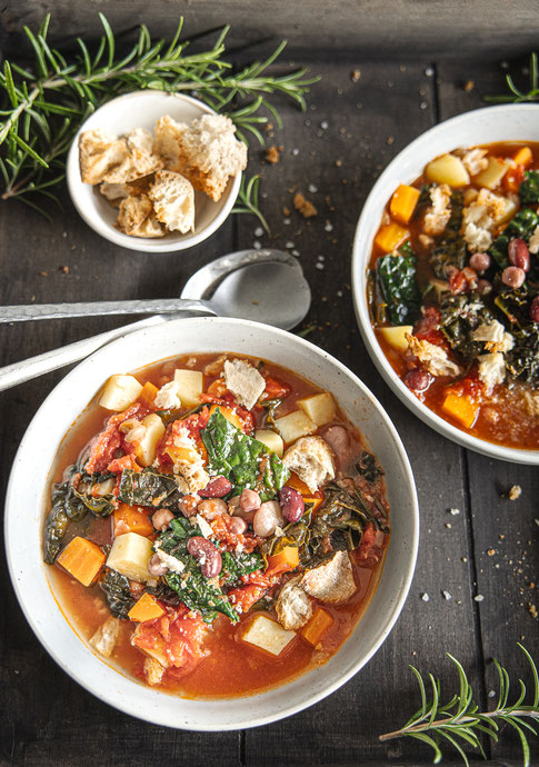 Toskanische Ribollita mit Palmkohl, weißen Bohnen und geröstetem Ciabatta - herzhafte, mediterrane Suppe in Schale serviert.