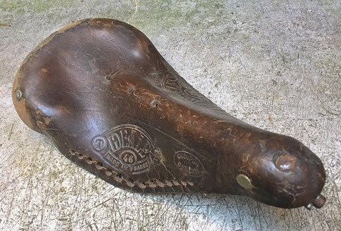 Deformierte Kernlederdecke eines historischen Fahrradsattels, Schäden an der Lederoberfläche durch Abrieb vom Benutzen des Sattels