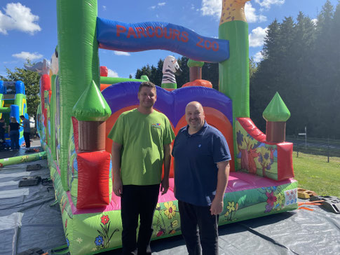 Bild Jochen Becker: Ortsbürgermeister Becker gratuliert Jan Hendrik Held vor einer der aufgebauten Hüpfburgen zum Jubiläum