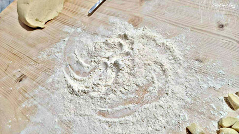Ripiano di legno da lavoro liscio con gli ingredienti pronti per la realizzazione homemade dei maccarrones de poddighe