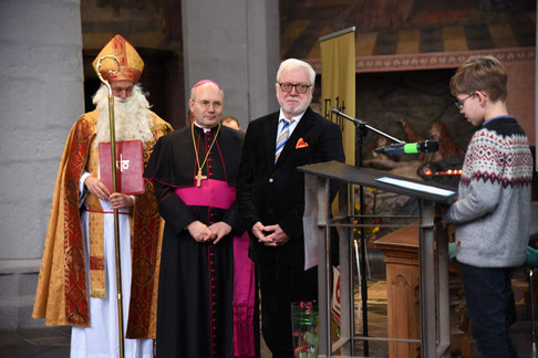 Ein Schüler trägt Bischof Nikolaus, Bischof Dieser und Bürgermeister Norbert Plum (v.l.) seine Forderungen gegen Kinderarbeit vor. © Theresa Meier