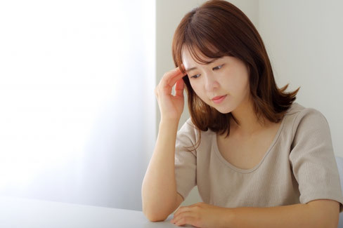 頭痛でうなだれる女性