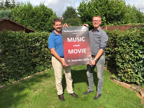 Vereinsvorsitzender Klaus Volkmer (l.) und Michael Kleene, zweiter Vorsitzender, präsentieren das Plakat zum Jahreskonzert „Music meets Movie“. 