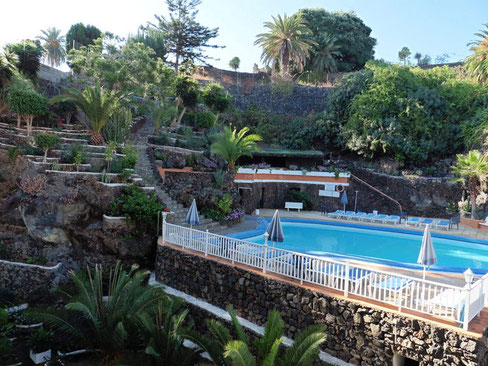 Poolanlage eingebettet in einen Terrassengarten mit subtropischen Pflanzen.