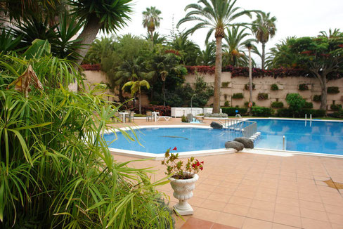 Großer Gemeinschaftspool in mitten einer Gartenlandschaft