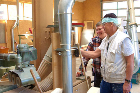 Petra und Stefan stehen in der Tischlerei und stellen einen Maschine an, um gleich mit der Fertigung von Holzfensterbänken loszulegen