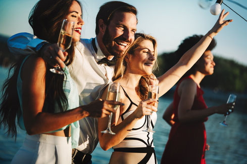 Corporate event in Ibiza, man elegantly dressed with three women infront of the sea