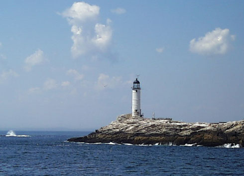 A lighthouse clinging to the rocks on one of the Isles of Shoals