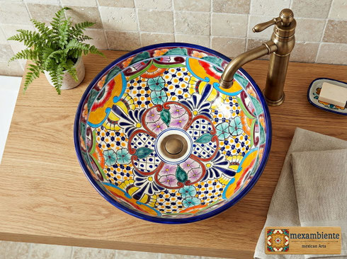 Rundes mexikanisches Waschbecken mit floralem Talavera-Muster in kräftigen Farben – Modell FRIDA – von oben fotografiert, auf Holzplatte mit Wandarmatur, farbenfrohes Design für individuelle Badezimmer.