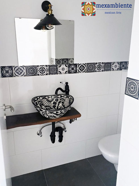 Schönes Badezimmer mit schwarzen und weißen Fliesen sowie einem passenden Waschbecken aus Mexiko in derselben Farbkombination.