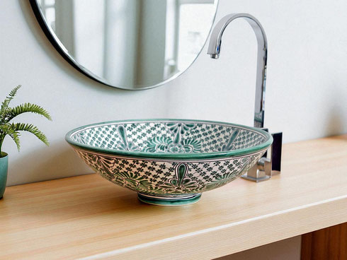 Mexikanisches Keramik-Waschbecken in Grün und Weiß mit floralen Mustern auf einem hellen Holzwaschtisch