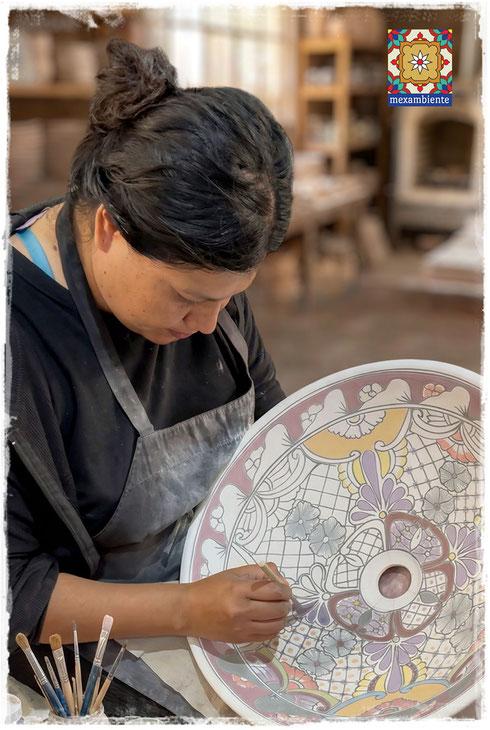 Mexikanische Kunsthandwerkerin bemalt ein Waschbecken aus Keramik im Talavera Stil von Hand, traditionelle Herstellung in Mexiko