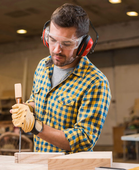 Hobby-Handwerker, der eine Holzkonstruktion mit Hammer und Nägeln fixiert