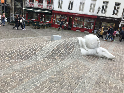 statua di bambino e cane all'interno della pavimentazione di una strada del centro di Anversa