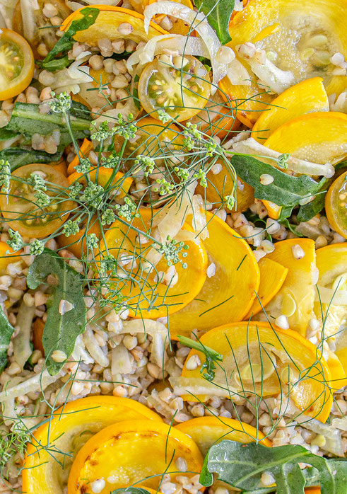Bunter Buchweizensalat mit gebratener Zucchini, frischem Fenchel und gelben Tomaten auf einem Teller – leichter Sommersalat.